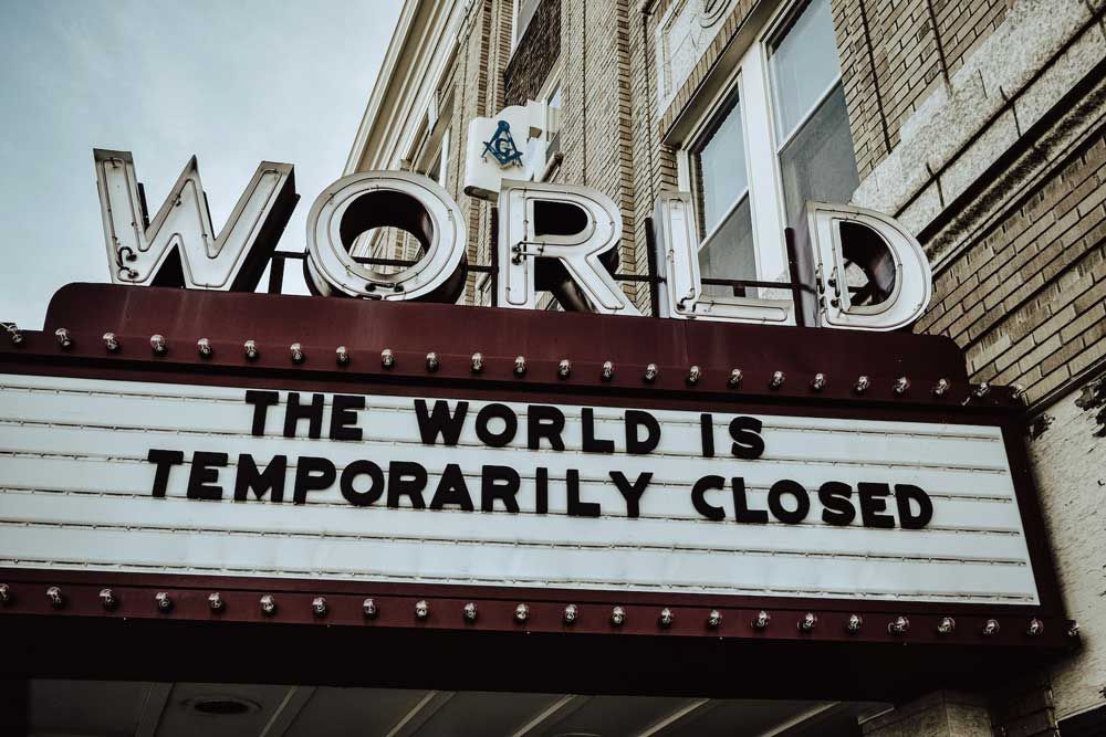 Image of movie theater marquee that says "The World is Temporarily Closed."